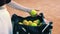 young woman taking balls out of a bag on a tennis court