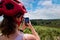 Young woman taking a break in mountain biking to take pictures with her smartphone