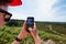 Young woman taking a break in mountain biking to take pictures with her smartphone