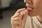 Young woman taking dietary supplement pill, closeup