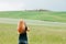 Young woman taking a photo of a beautiful landscape in Tuscany