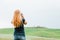 Young woman taking a photo of a beautiful landscape in Tuscany