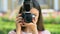 Young woman taking photo by camera and smiling, female photojournalist, blogger