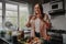 Young woman taking photo of her food with smart phone in modern kitchen at home during isolation and quarantine