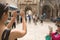 Young woman taking a photo with her smartphone. Woman tourist capturing memories. Tourist tour around city. Young woman tour
