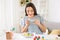 Young woman taking photo of painted Easter eggs at home