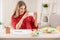 Young woman taking photo of painted Easter eggs at home