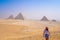 Young woman taking photos with Pyramids of Giza view