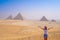Young woman taking photos with Pyramids of Giza view