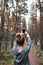 Young woman taking photos using smartphone during walk in a forest on summer vacation trip