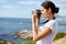 Young woman taking pics of the ocean