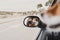 Young woman taking a picture with camera on rear mirror of her cute small jack russell dog watching by the window. Ready to travel