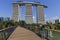 Young woman taking a picture of the Marina Bay Sands hotel from the gardens by the bay