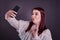 Young woman taking selfie lips puckered and peace sign