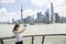 Young woman taking selfie while standing by railing against Pudong skyline