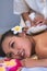 Young woman taking Thai Herbal ball hot compress massage in an authetic spa authentic