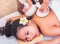 Young woman taking Thai Herbal ball hot compress massage in an authetic spa authentic