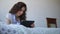 Young woman talking with friends using tablet while lying in bed in the bedroom.