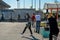 Young woman talking on phone,gloves on her hands. Background of people in line with shopping carts and face masks