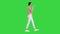 Young woman talking on the phone holding it to her face while walking on a Green Screen, Chroma Key.