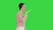 Young woman talking on the phone holding it to her face while walking on a Green Screen, Chroma Key.