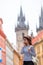 Young woman talking by smartphone background famous castle in european city. Caucasian tourist walking along the