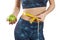 Young woman with tape measure around waist and apple