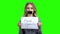 Young woman with taped mouth on green screen.