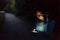 Young woman tapping on phone outdoor at night. Blur park background