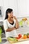 Young woman tasting vegetables in kitchen