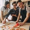 Young woman teach her friends how to cook food. People cooking p