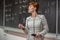 Young woman teacher in college. Instruction in a university classroom. Blackboard described by chalk. Projection from