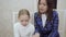 Young woman teacher and little girl sinning and playing the piano together.