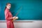 Young woman teacher stands at a blackboard with a pointer. Template for the school timetable and other information.