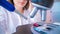 Young woman technician is examining a histological sample, a biopsy in the laboratory of cancer research