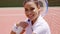 Young Woman with Tennis Racket Sitting on Court