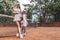 Young woman tennis trainer and sporty girl child on court