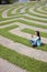 Young Woman Text Messaging in a Grass Maze