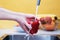 Young woman thoroughly washes vegetables