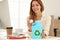 Young woman throwing paper into mini recycling bin