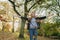 A young woman throws leaves in a park