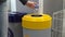 A young woman throws a plastic bottle into the trash. Special containers for sorting garbage. Container for plastic