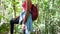 Young woman tied shoelaces and continue walking in the forest with trip companion