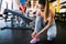 Young woman is tighten or laces the shoes in gym.