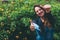 A young woman took off a blue medical mask and rejoices at the end of quarantine, shows with her hands a super sign in the park.