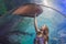 A young woman touches a stingray fish in an oceanarium tunnel