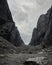 A young woman tourist with a backpack goes through a lifeless rocky pass.