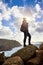 Young woman tourist at Cape Cabo da Roca standing on the rocky edge of the cliff. The waves of the ocean break on the rocks at the