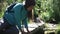 Young woman tourist drink water, wets hands in a mountain river. Slider 50 fps