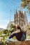 Young woman tourist in front of the famous Sagrada Familia landmark in Barcelona